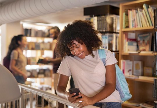 Étudiante consultant son téléphone dans la bibliothèque