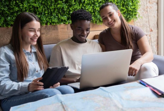 Trois étudiants travaillant ensemble autour d'un ordinateur portable